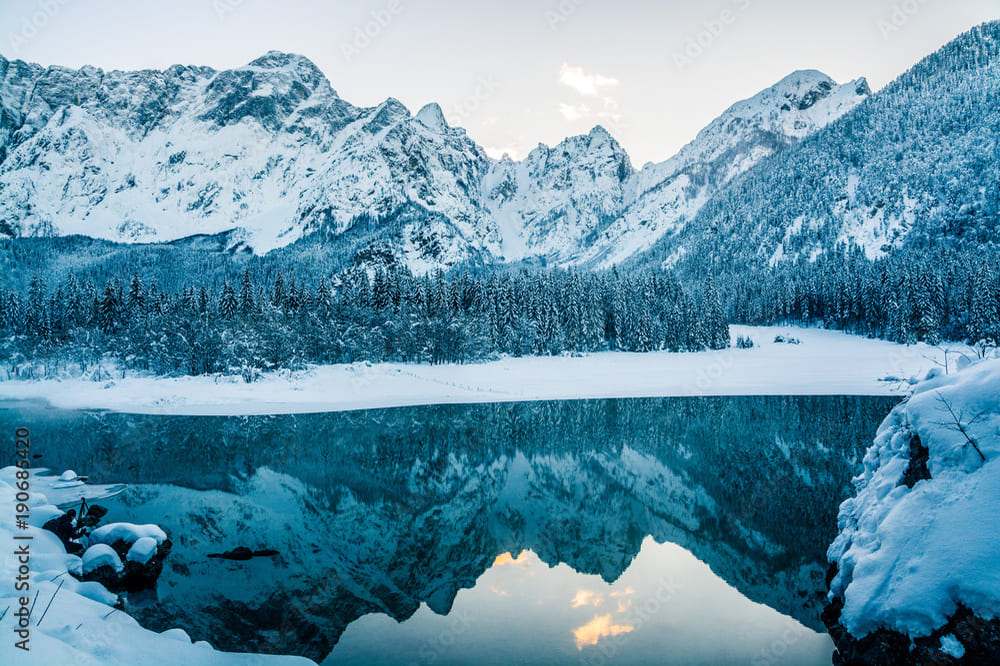 Lago di Fusine Inferiore innevato con Alpi Giulie