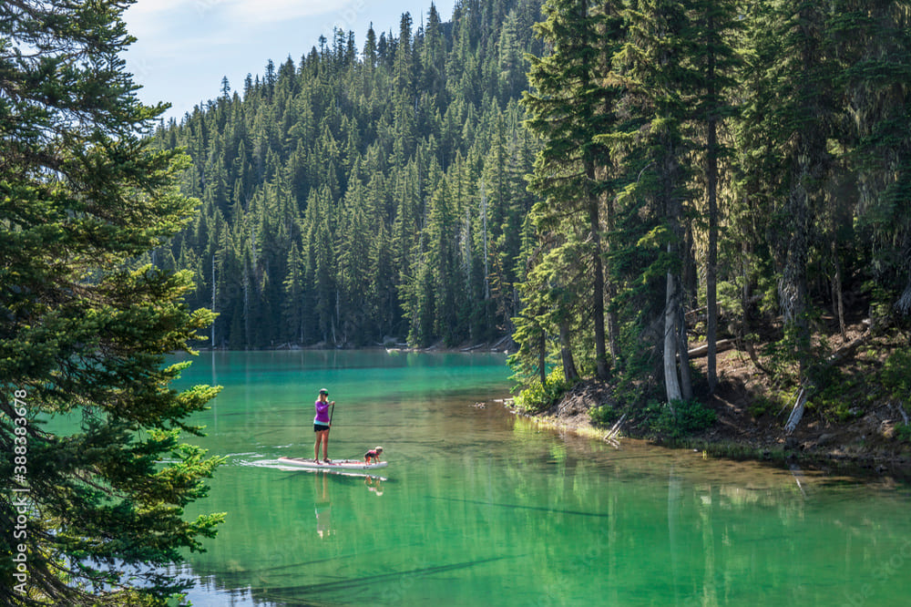 Gruppo di persone che praticano SUP sul Lago di Fusine con vista sulle Alpi Giulie
